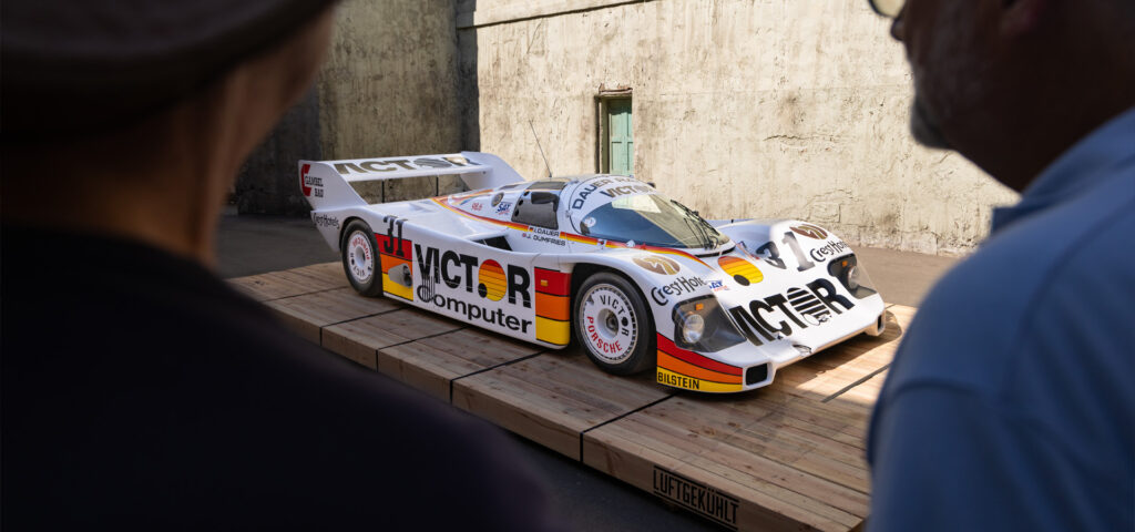 two people standing looking at racecar